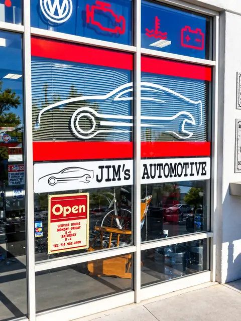 Jim's Automotive front windows with a car outline decal, the Jim's Automotive name and a red Open sign